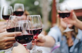 people tossing their clear wine glasses
